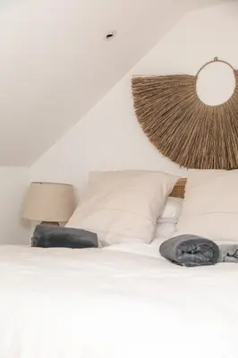 a bedroom with a white bed with two pillows at Lowen Tree House in Truro