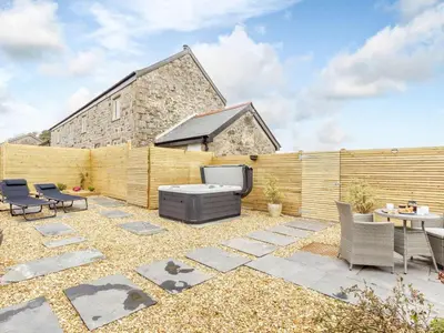a patio with a tv and chairs and a fence at 1 Bed in Redruth oc-85826 in Gwennap