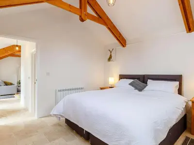 a bedroom with a large white bed and wooden ceilings at 1 Bed in Redruth oc-85826 in Gwennap