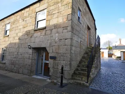 a brick building with a staircase next to a door at 1 Bed in St. Austell oc-42194 in Charlestown