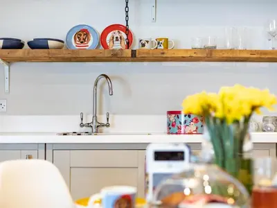 a kitchen counter with a sink and a vase of yellow flowers at 1 Bed in St. Austell oc-42194 in Charlestown