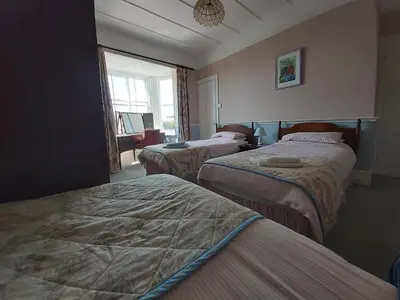 a hotel room with three beds and a window at The Fieldings in Truro