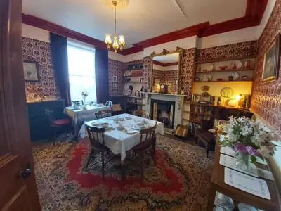 a dining room with a table and a fireplace at The Fieldings in Truro