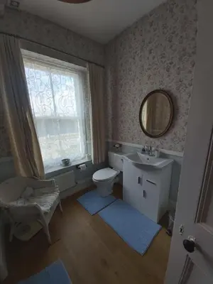a bathroom with a toilet and a sink and a mirror at The Fieldings in Truro