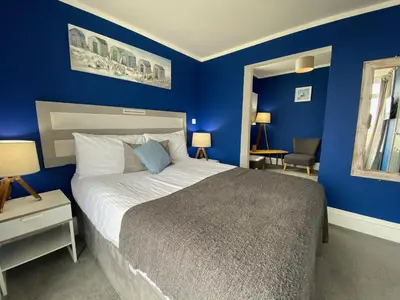 a bedroom with blue walls and a large bed at The Lyncroft in Newquay