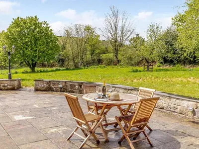 a patio with a table and chairs and a field at 2 Bed in St. Austell oc-79594 in Saint Stephen