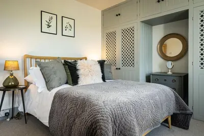 a bedroom with a large bed and a mirror at Harewood, Port Isaac Bay Holidays in Port Isaac