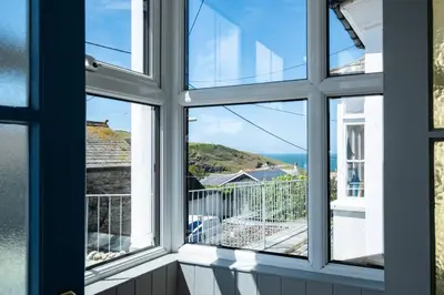 a room with a window with a view of the ocean at Harewood, Port Isaac Bay Holidays in Port Isaac