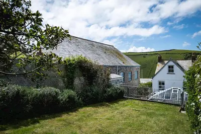 an old building with a fence and a yard at Harewood, Port Isaac Bay Holidays in Port Isaac