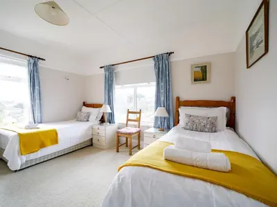 a bedroom with two beds and a window at Trevarthian in Polzeath
