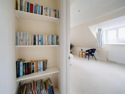 a room with shelves filled with books at Trevarthian in Polzeath
