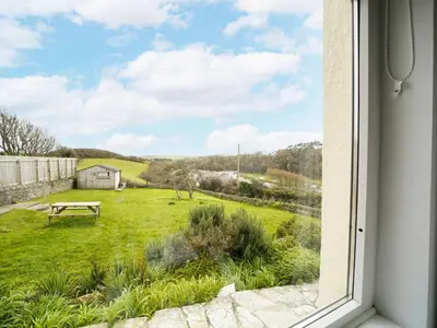 a view from a window of a yard at Trevarthian in Polzeath