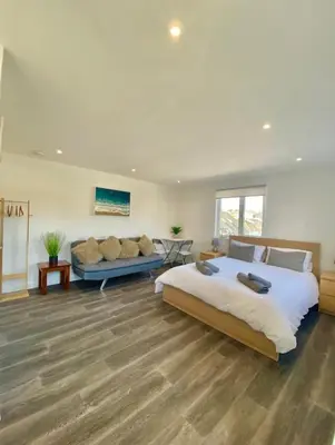 a bedroom with a large bed and a couch at Casa Studio in St Ives