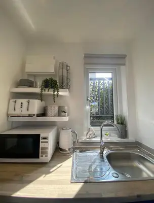 a kitchen with a sink and a microwave at Casa Studio in St Ives