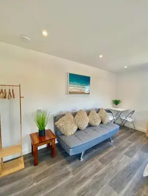 a living room with a blue couch and a table at Casa Studio in St Ives