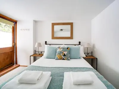a bedroom with a large white bed with two pillows at Stanley House in Port Isaac
