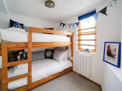 a bedroom with two bunk beds and a window at Stanley House in Port Isaac