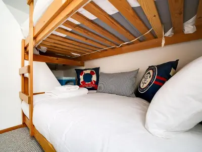 two bunk beds in a room with wooden ceilings at Stanley House in Port Isaac
