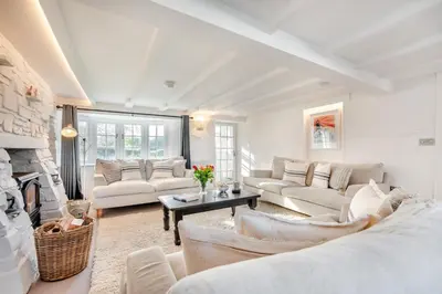 a living room with white furniture and a fireplace at 4 Bed in St. Merryn oc-e28379 in St Merryn