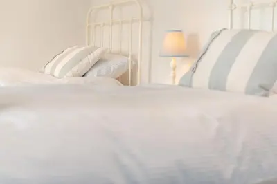 a bedroom with two white beds and a lamp at 4 Bed in St. Merryn oc-e28379 in St Merryn
