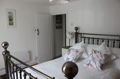 a bedroom with a bed with pillows on it at Lil' Nauti in Pentewan