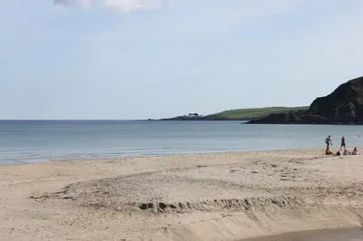 a group of people standing on a beach at Lil' Nauti in Pentewan