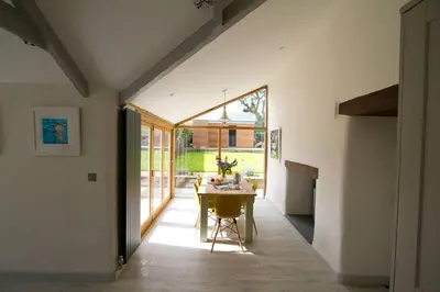 a dining room with a table and a large window at Barnwell Cottage *Stunning Cornish Cottage* Oozing Charm + Comfort in Cubert