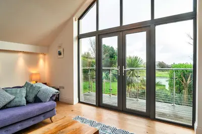an open living room with sliding glass doors at Finest Retreats - Dingles Cottage in Philleigh