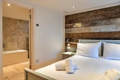 a bedroom with a bed and a bath tub at Finest Retreats - Dingles Cottage in Philleigh