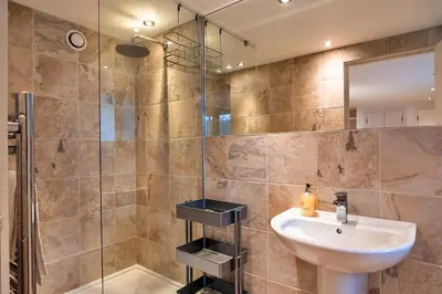 a bathroom with a sink and a glass shower at Finest Retreats - Dingles Cottage in Philleigh