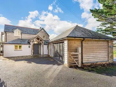 a large wooden house with a large garage at Finest Retreats - Dingles Cottage in Philleigh