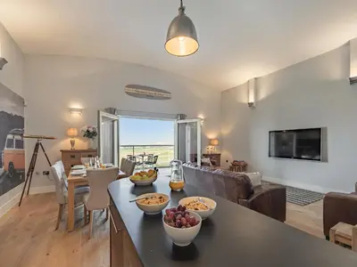 a living room with a table with bowls of fruit on it at The Vista in Newquay