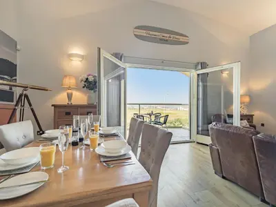 a dining room with a table and chairs with a view at The Vista in Newquay