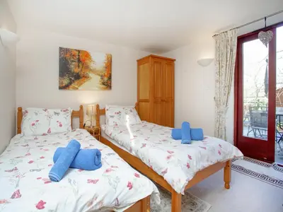 two twin beds in a room with a window at Bulls Cottage in Bodmin