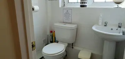 a white bathroom with a toilet and a sink at 11 Granite Henge in Pelynt