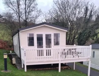 a pink tiny house with a white deck at Seaside View Caravan in Polperro in Looe