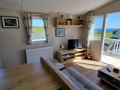 a living room with a couch and a table at Seaside View Caravan in Polperro in Looe
