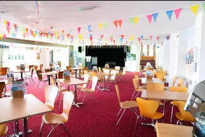 an empty classroom with tables and chairs and flags at Seaside View Caravan in Polperro in Looe