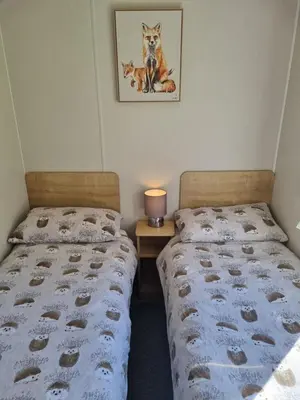 two beds sitting next to each other in a bedroom at Seaside View Caravan in Polperro in Looe