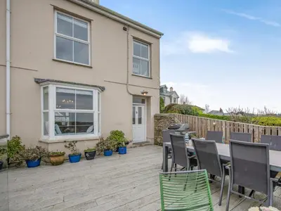 a patio with a table and chairs in front of a house at 4 Bed in Polruan oc-pc044 in Fowey
