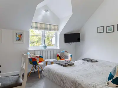 a bedroom with a bed and two chairs and a window at 5 Bed in Redruth oc-65745 in Gwennap