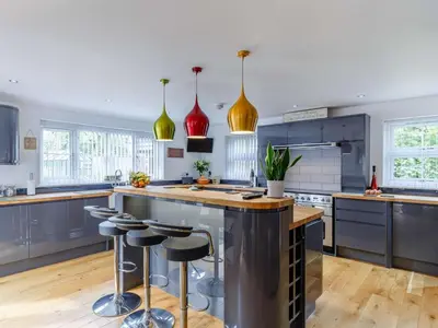 a kitchen with a large island with bar stools at 5 Bed in Redruth oc-65745 in Gwennap