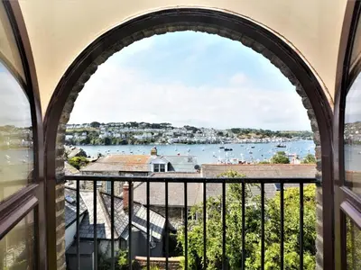 an arched window with a view of the water at 2 Bed in Fowey oc-75740 in Polruan