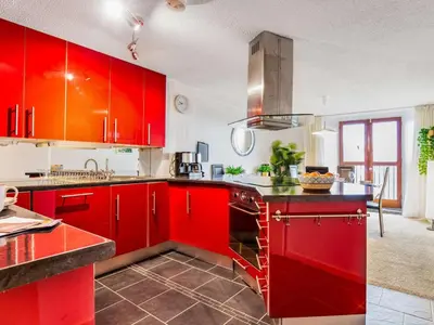 a kitchen with red cabinets and a red counter top at 2 Bed in Fowey oc-75740 in Polruan