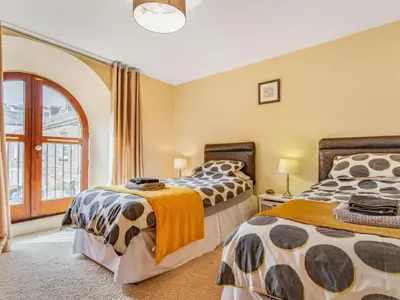 two beds in a room with a window at 2 Bed in Fowey oc-75740 in Polruan