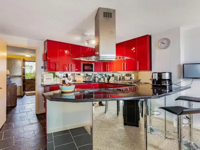 a kitchen with red cabinets and a large kitchen island at 2 Bed in Fowey oc-75740 in Polruan