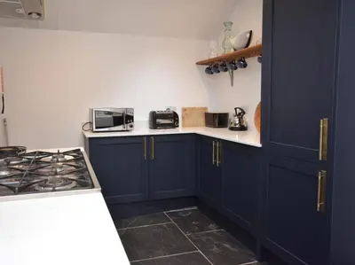a kitchen with navy blue cabinets and a stove at 3 Bed in Fowey oc-82101 in Fowey
