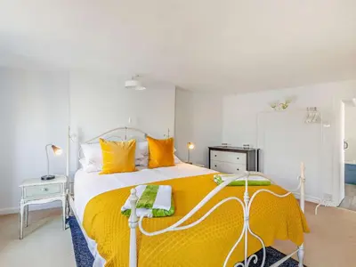 a bedroom with a large bed with yellow pillows at 3 Bed in Polruan oc-83821 in Fowey