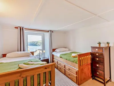 a bedroom with two beds and a window at 3 Bed in Polruan oc-83821 in Fowey