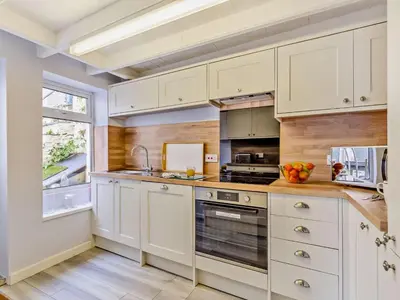 a kitchen with white cabinets and a window at 3 Bed in Polruan oc-83821 in Fowey